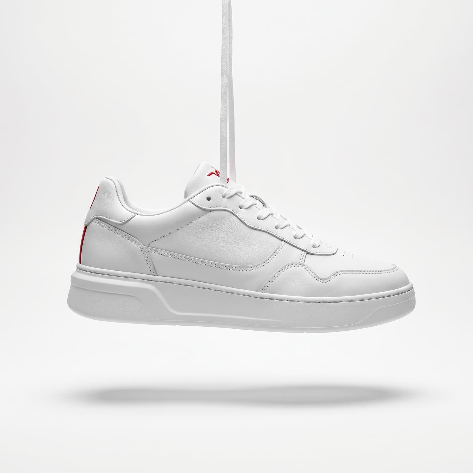 Red-and-white leather sneakers on a white sole