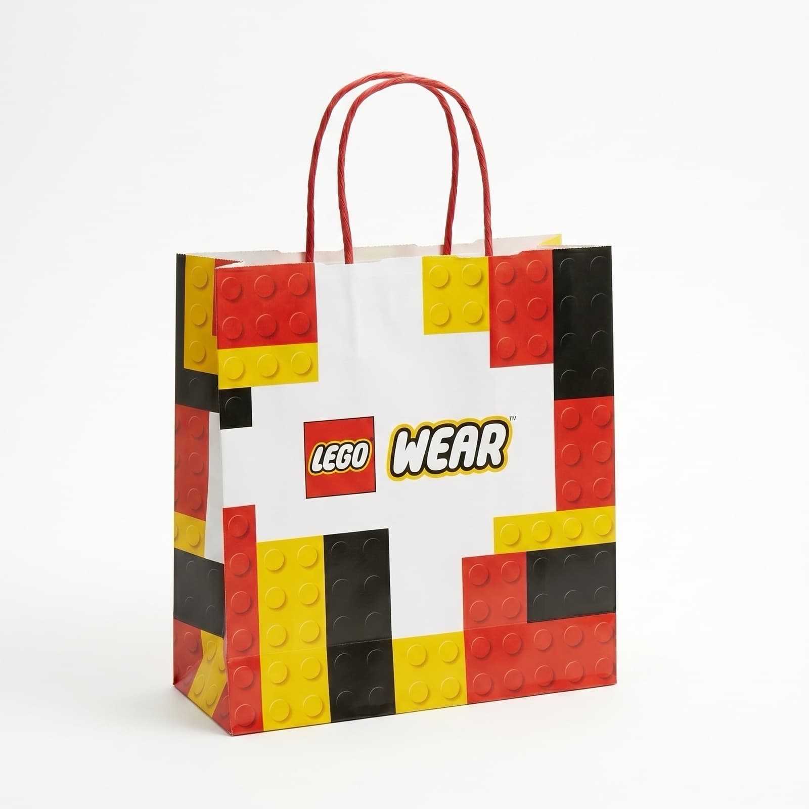A paper shopping bag carrying the LEGO Wear logo